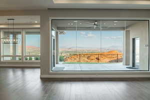 Room details featuring a mountain view, ceiling fan with notable chandelier, and hardwood / wood-style floors