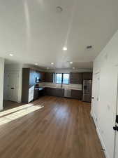 Kitchen with dark brown cabinetry, sink, dark wood-type flooring, and stainless steel appliances