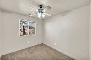 Carpeted empty room with ceiling fan and a textured ceiling