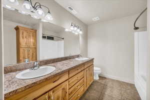 Bathroom featuring vanity, tile patterned floors, and toilet