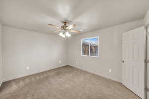 Spare room featuring light carpet, a textured ceiling, and ceiling fan