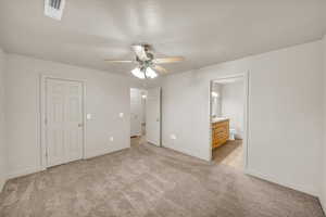 Unfurnished bedroom featuring ceiling fan, connected bathroom, and light carpet