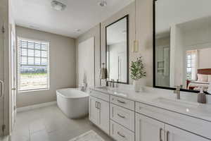 Primary Bathroom featuring tile patterned floors, vanity, and separate shower and tub