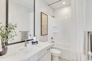 Full bathroom featuring shower / bath combo with shower curtain, vanity, and toilet