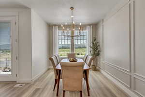 Dining area with light hardwood / wood-style flooring and a chandelier