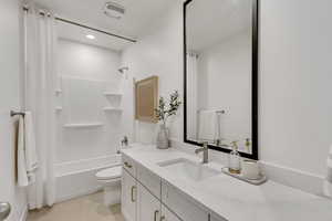 Basement Full bathroom featuring vanity, toilet, and shower / tub combo with curtain