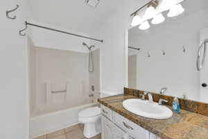 Full bathroom with tile patterned floors, toilet, shower / bathing tub combination, and vanity