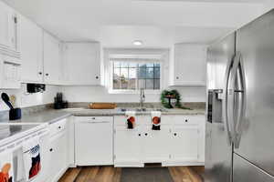 Kitchen with dark hardwood / wood-style flooring, sink, white appliances, and white cabinets