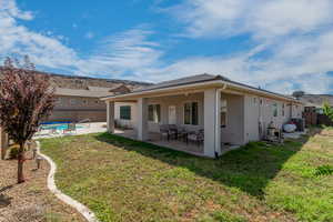 Rear view of house with a lawn, a patio, and central air condition unit