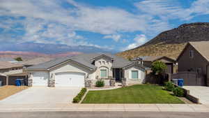 View of front of house with a garage, a mountain view, and a front yard