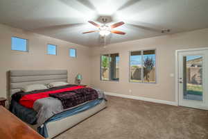 Carpeted bedroom featuring ceiling fan and a textured ceiling