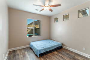 Bedroom featuring dark hardwood / wood-style flooring and ceiling fan