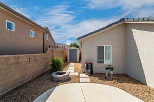 Exterior space featuring a storage shed and a fire pit