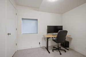 Carpeted office space featuring a textured ceiling