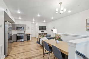 Dining room featuring an inviting chandelier, light hardwood / wood-style floors, and a textured ceiling