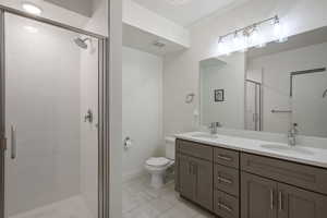 Bathroom with vanity, an enclosed shower, and toilet