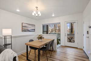 Dining space featuring a chandelier, light hardwood / wood-style flooring, and a textured ceiling