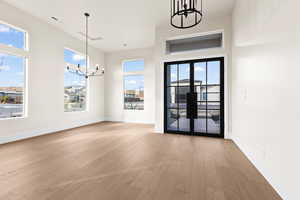 Interior space featuring light hardwood / wood-style flooring, french doors, and a chandelier