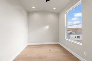 Unfurnished room with vaulted ceiling and light hardwood / wood-style floors