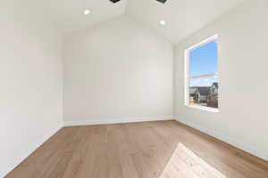 Unfurnished room with vaulted ceiling, ceiling fan, and light hardwood / wood-style floors