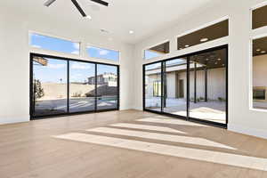 Spare room with a towering ceiling and light hardwood / wood-style floors