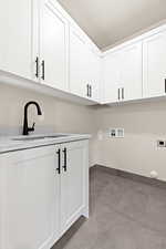 Washroom featuring sink, hookup for a washing machine, cabinets, and hookup for an electric dryer