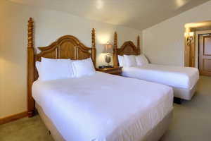 Bedroom featuring vaulted ceiling and light carpet