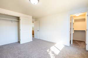 Unfurnished bedroom with carpet, baseboards, and a closet