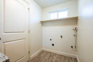 Laundry room featuring baseboards, laundry area, electric dryer hookup, and light wood-style floors