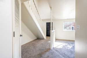 Additional living space featuring carpet, stairs, and baseboards