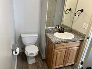 Bathroom featuring vanity, hardwood / wood-style floors, and toilet