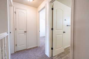 Hallway featuring baseboards and light colored carpet