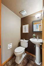 Bathroom with sink, a textured ceiling, and toilet