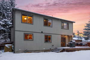 View of snow covered back of property