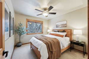 Bedroom with ceiling fan and light carpet