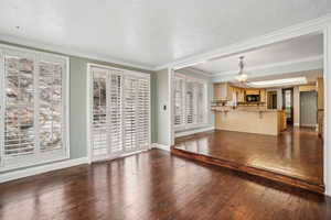 Dining room with bar seating, plantation shutters, hardwood floors