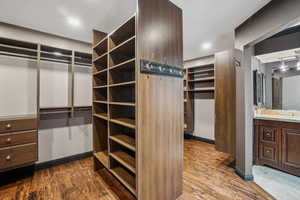 Huge master bathroom closet organizer system featuring hardwood floors