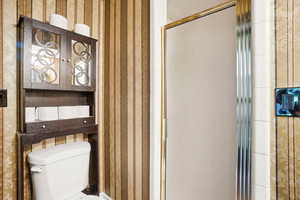 Main floor Bathroom  with toilet and organizer shelves