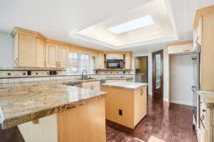 Kitchen with granite countertops, center island, a skylight