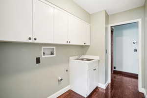 Laundry room with utility sink, loads of cabinets and a closet, hardwood flooring with electric washer/dryer hookups