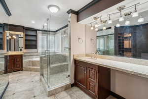 Master bathroom featuring vanity, ornamental molding, and large walk in shower with bench seating