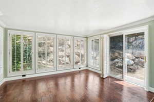 Sunroom with lots of windows and plantation shutters, sliding glass door to hot tub area and trex deck