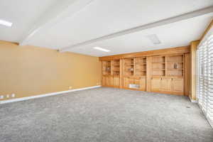 Theater room with oak shelving, automatic projection screen, ready for new theator equipment.  Plantation shutters, New carpet