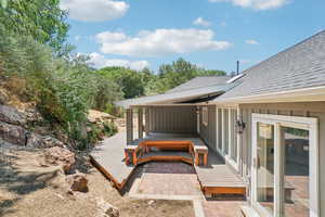 View of trex deck from private alcove with large boulders.  Very private.  Sliding glass doors enter into the sunroom.  Wood door leading to kitchen with doggie door