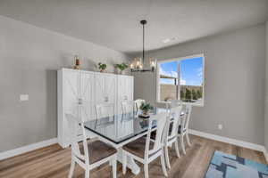 Dining room featuring a chandelier, light hardwood / wood-style floors, and a textured ceiling