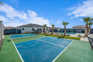 View of tennis court featuring a fenced in pool