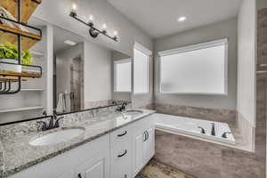 Bathroom featuring vanity and tiled tub