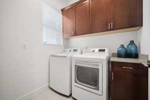 Washroom featuring cabinets and separate washer and dryer