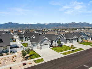 Ranch-style house featuring a garage, a mountain view, and a front lawn