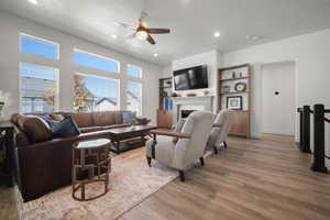 Living room with ceiling fan, light hardwood / wood-style floors, and a textured ceiling